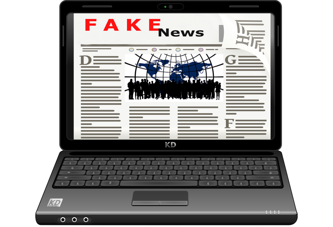Désinformation Un exemplaire de journal dans un ordinateur avec l'épigraphe Fake news.